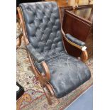 A mahogany open armchair upholstered in buttoned black leather