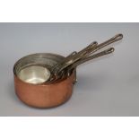 A graduated set of five copper saucepans