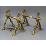 A pair of brass fire dogs in the manner of Christopher Dresser height 24cm