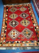 A Qashqai brick red ground geometric rug 175 x125 cm