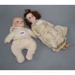 An A.M. open mouthed bisque headed doll and a baby doll