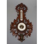 A late 19th century German carved walnut barometer and thermometer, by Rudolph Strange, Bunde and