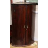 A George III mahogany bow front hanging corner cupboard W.65cm