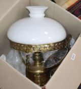 A brass hanging oil lamp with white glass shade