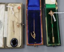 A 15ct gold 'wishbone' stickpin, a diamond gypsy-set example and three other stickpins.