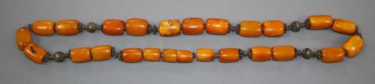 A Persian single strand barrel shaped amber bead and metal mounted necklace, gross weight 146 grams,