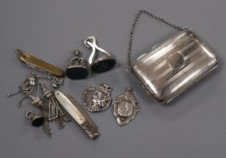 A George V silver purse, three silver fob seals, two fobs and sundries.
