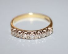 An 18ct gold and seven stone diamond half hoop ring, size N.