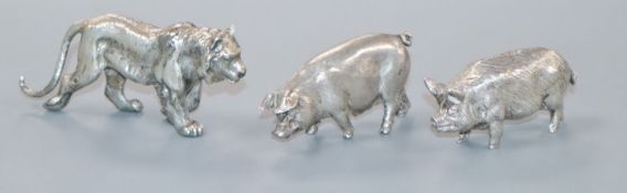 Two modern silver miniature models of pigs and a white metal lion.