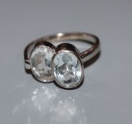 A French 18ct white metal and twin stone oval cut aquamarine dress ring, size N.