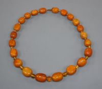 A single strand graduated amber bead necklace and loose beads, gross 96 grams, with spacers, 54cm.