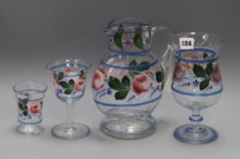 A hand painted decoration glass set consisting of a jug and three types of glass, French in origin