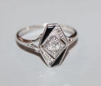 An Art Deco style white metal, diamond and black onyx dress ring, size L.