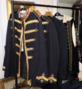 Two gold braided guards uniforms, another and a black velvet theatrical costume