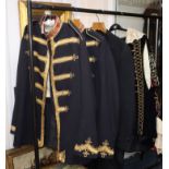 Two gold braided guards uniforms, another and a black velvet theatrical costume