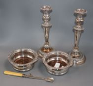 A pair of Sheffield plate candlesticks, a pair of plated wine coasters and a patent action plated