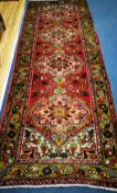 A Karajeh red ground rug 296 x 110cm