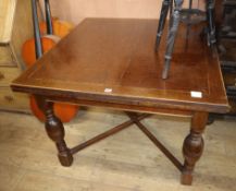 A 1920's oak draw-leaf dining table W.107cm