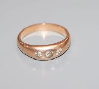A 585 yellow metal and gypsy set three stone diamond ring, size O.