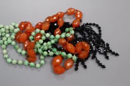 A jade necklace, carnelian necklace and black paste necklace.