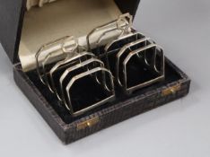 A cased pair of 1930's silver five bar toastracks by Henry Clifford Davis, length 7cm.