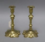 A pair of George I brass candlesticks with knopped stems on petal bases height 19cm