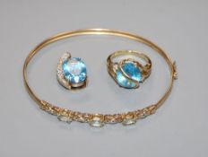 A 9ct gold and blue topaz set dress ring, a similar pendant and a 9k gem set bangle.