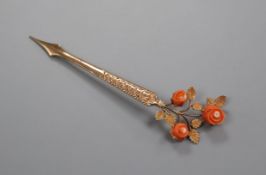An early 20th century continental yellow metal and carved coral hair ornament? 95mm.