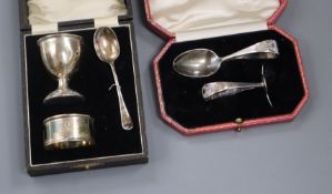 A cased child's silver pusher and similar egg cup spoon and napkin ring.