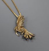 A yellow metal and gem set hummingbird pendant, on a 9ct gold chain, pendant 27mm.