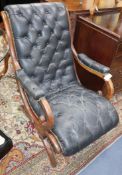 A mahogany open armchair upholstered in buttoned black leather