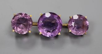 A yellow metal and three stone amethyst set brooch, 44mm.
