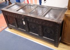 A mid 17th century oak coffer, the arched panelled front carved with rosettes W.150cm
