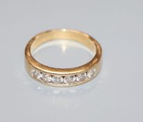 A modern 18ct gold and channel set six stone diamond ring, size M.