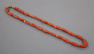 An Italian elongated coral bead necklace with 750 yellow metal clasp and spacers, 44cm.