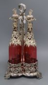 A decanter stand with three cranberry glass decanters and stoppers height 45cm