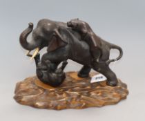 A Japanese Meiji period bronze figure of tigers attacking an elephant, signed, on carved wood base