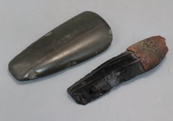 A Neolithic stone hand axe and an obsidian blade with knapped edges and the remains of a carved wood