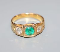 An 18ct gold, emerald and diamond set three stone ring, size O.
