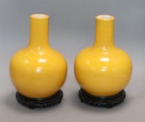 A pair of yellow ground bottle vases, on hardwood stands Height excluding stands 25cm