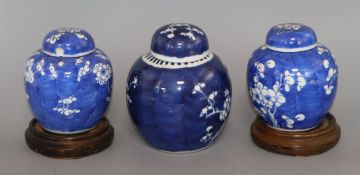 A Chinese ginger jar and cover decorated with prunus and a similar smaller pair of ginger jars on