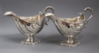 A pair of George III silver pedestal sauceboats, London, 1763?, (repairs), height 16cm, marks