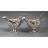 A pair of George III silver pedestal sauceboats, London, 1763?, (repairs), height 16cm, marks