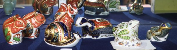 A collection of seven Crown Derby animal paperweights: three squirrels, a snail, a badger and two