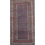 A Saraband blue ground rug, with central field of stylised pears and a six row border, 6ft 2in by