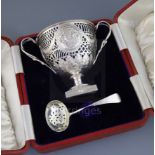 A cased Edwardian two handled pierced silver sugar vase with blue glass liner, by Nathan & Hayes,