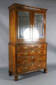 An early 18th century figured and burr walnut cabinet on chest, with moulded cornice and two