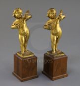 A pair of 17th century Italian gilt metal figures of putto playing mandolins, on later hardwood