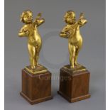 A pair of 17th century Italian gilt metal figures of putto playing mandolins, on later hardwood