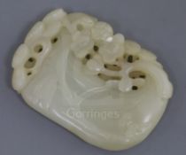 A Chinese pale celadon jade plaque, carved and pierced with a pine bough and prunus, 6.2cm